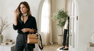 A high-end editorial fashion shot of a stylish woman accessorizing a minimalist outfit with a curate