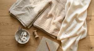 A high-quality, editorial-style flat lay photography of soft, premium natural fabrics like organic c